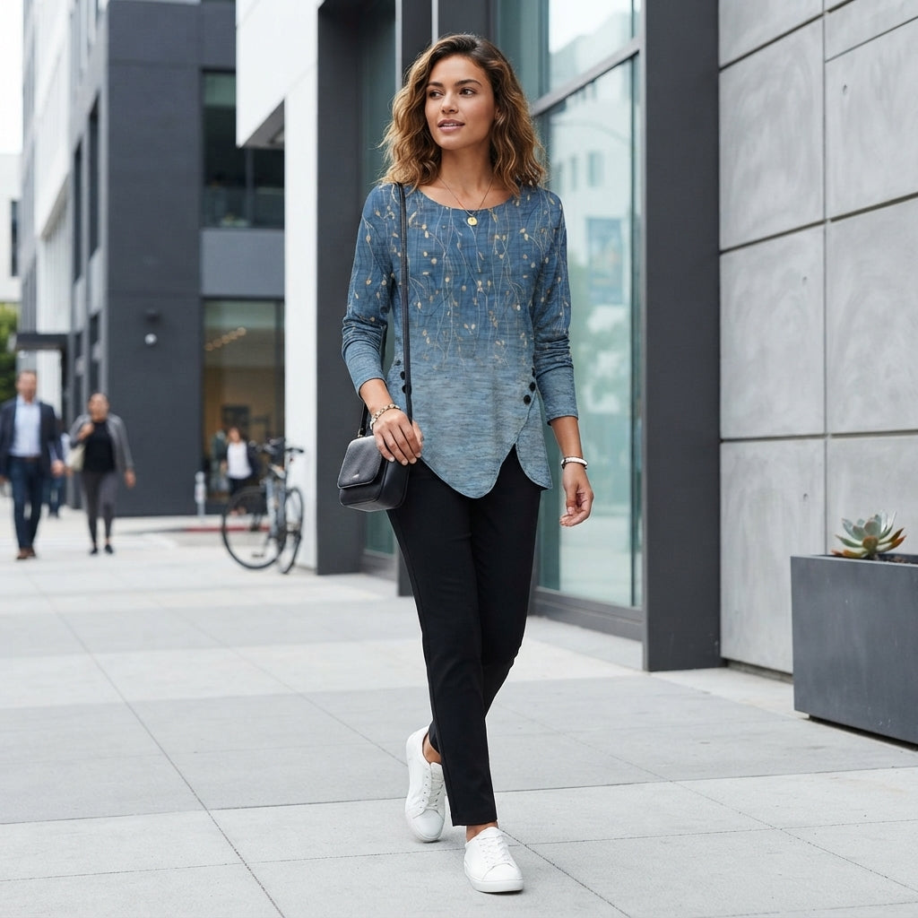 A woman wearing a long-sleeve 3D retro-printed top with an irregular hem walking down a city street.